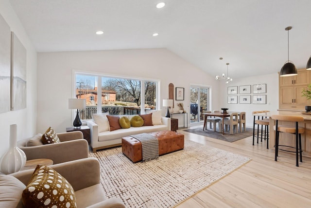 living area with lofted ceiling, light wood finished floors, a notable chandelier, and recessed lighting