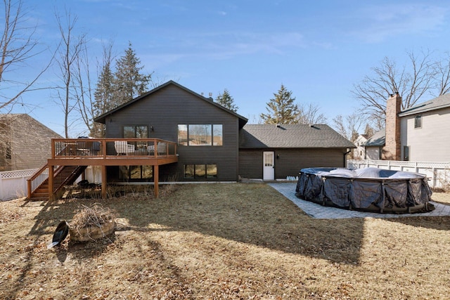 back of property with a fenced in pool, fence, stairway, and a wooden deck