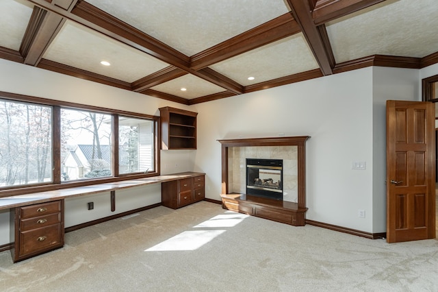 unfurnished office with coffered ceiling, baseboards, light colored carpet, and built in study area