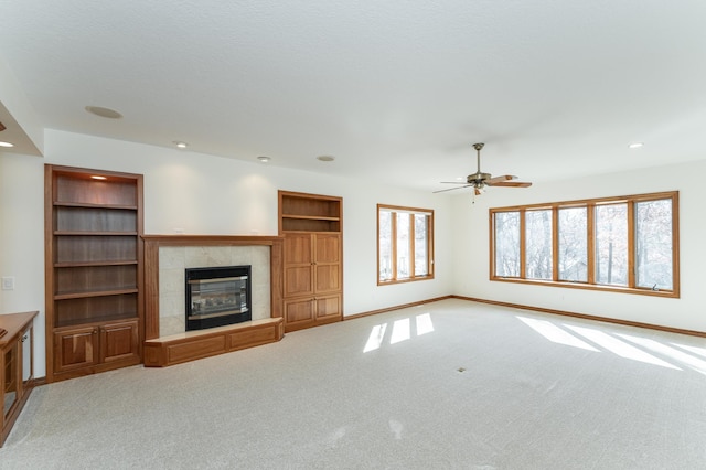 unfurnished living room with carpet, recessed lighting, a fireplace, and baseboards