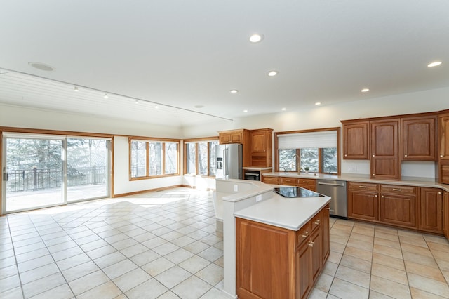 kitchen featuring light tile patterned floors, appliances with stainless steel finishes, a kitchen island, and light countertops