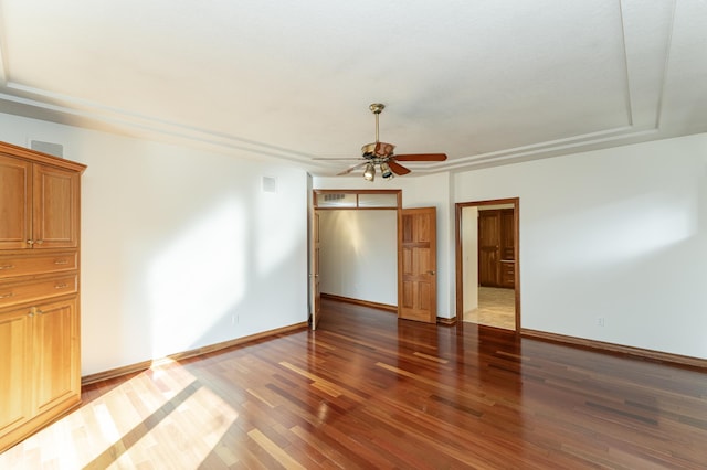 empty room featuring visible vents, wood finished floors, baseboards, and ceiling fan