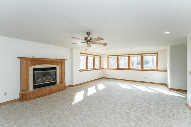 unfurnished living room with plenty of natural light, light colored carpet, baseboards, and a premium fireplace