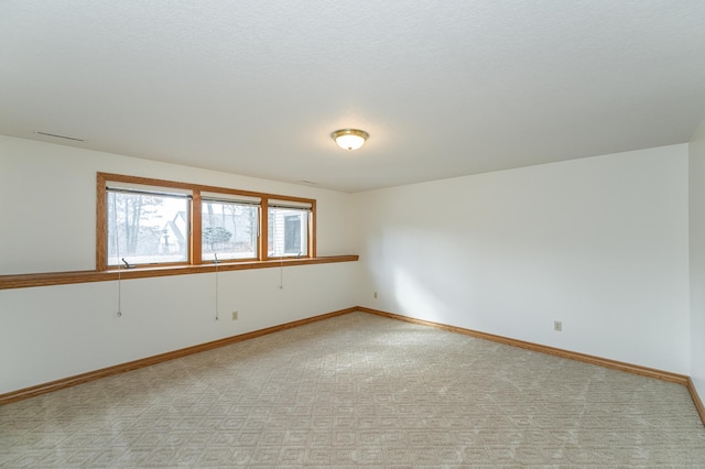 empty room with baseboards and light carpet