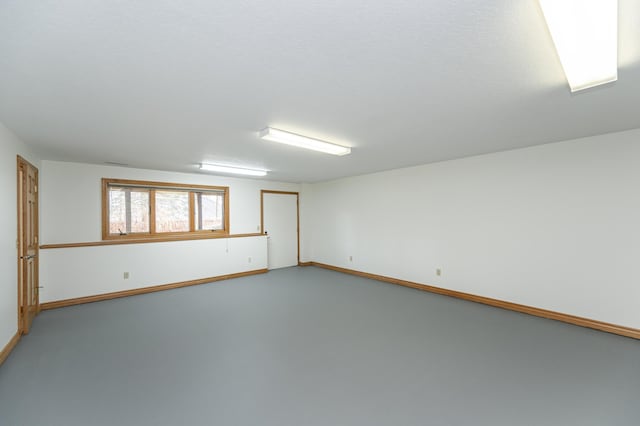 empty room with concrete floors and baseboards