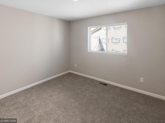 carpeted empty room featuring baseboards and visible vents