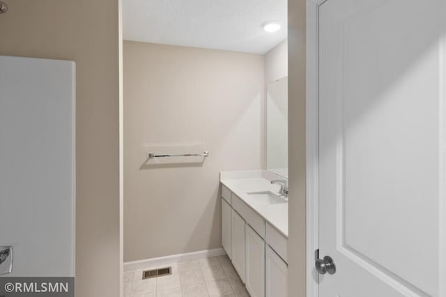 bathroom featuring tile patterned floors, vanity, visible vents, and baseboards