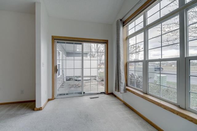 spare room featuring baseboards, visible vents, and carpet flooring