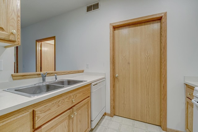 kitchen featuring light floors, light countertops, visible vents, white dishwasher, and a sink