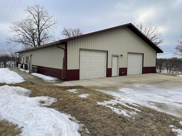 snow covered garage featuring a garage