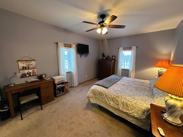 bedroom featuring light carpet, ceiling fan, and baseboards