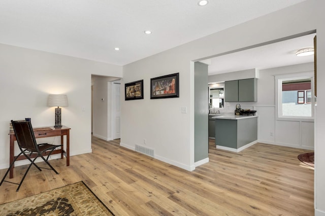 interior space with light wood finished floors, baseboards, visible vents, and recessed lighting