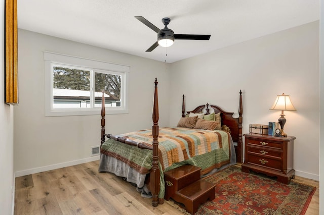 bedroom featuring light wood-style floors, visible vents, baseboards, and a ceiling fan