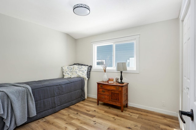 bedroom with light wood finished floors and baseboards