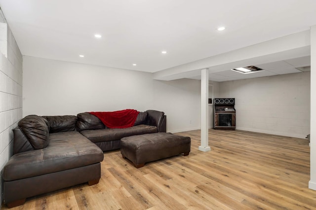 living room featuring light wood finished floors, concrete block wall, visible vents, and recessed lighting