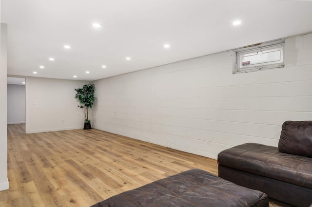 living area with recessed lighting, concrete block wall, and light wood-style floors