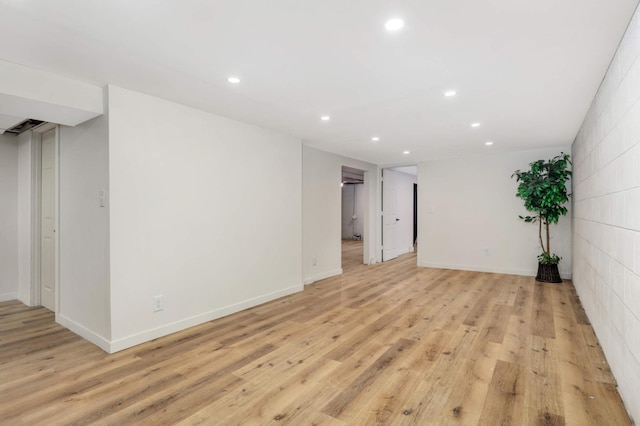 spare room featuring light wood-type flooring, recessed lighting, and baseboards