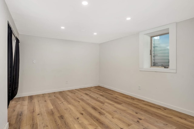 spare room featuring recessed lighting, light wood-style flooring, and baseboards