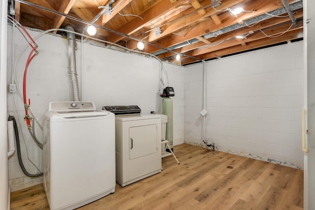 laundry room featuring laundry area, washing machine and dryer, and light wood-style flooring