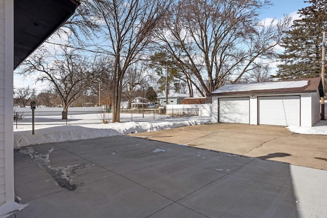 exterior space with a garage, an outdoor structure, and fence