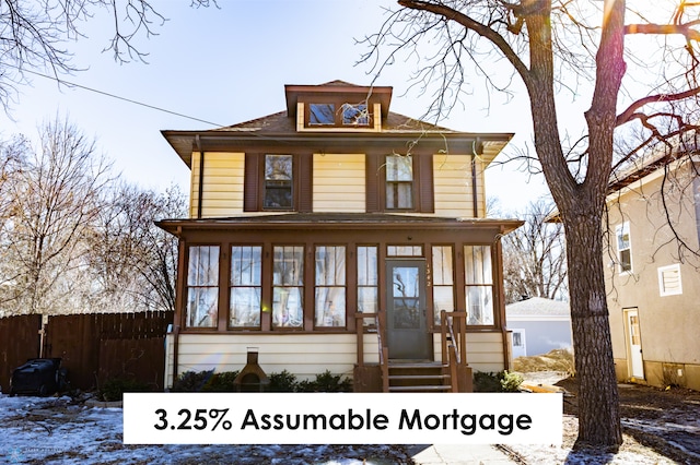 traditional style home with entry steps, a sunroom, and fence