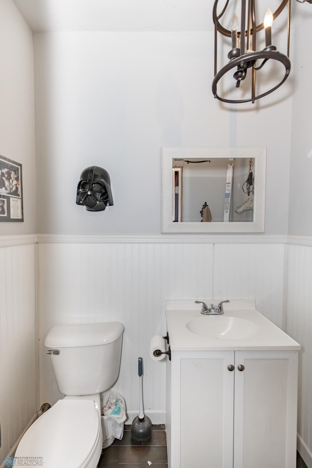 bathroom with toilet, wainscoting, wood finished floors, and vanity