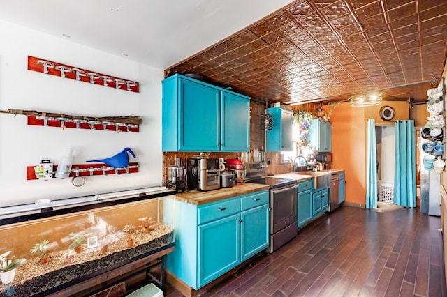 kitchen with dark wood finished floors, an ornate ceiling, blue cabinets, stainless steel appliances, and a sink