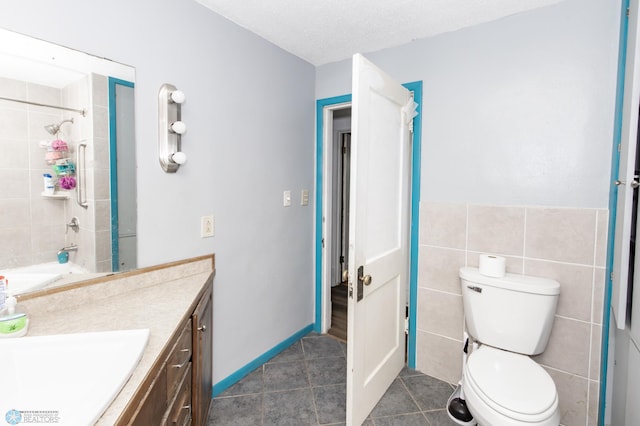 full bathroom with a shower, tile walls, vanity, and tile patterned floors