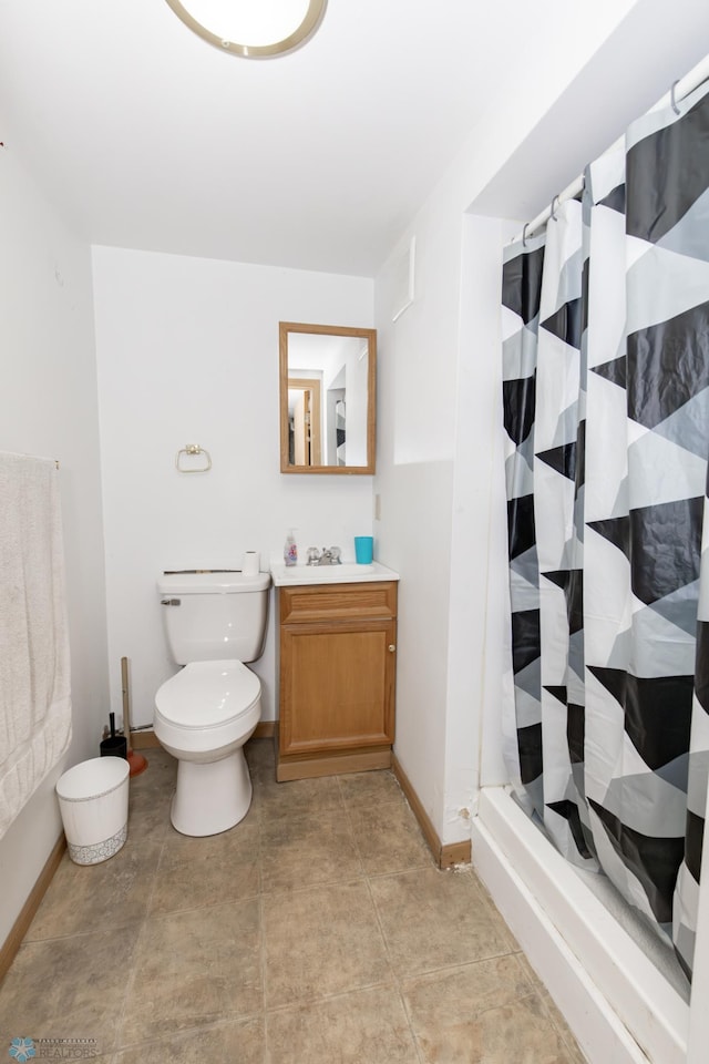 full bath featuring toilet, vanity, baseboards, tile patterned floors, and a stall shower