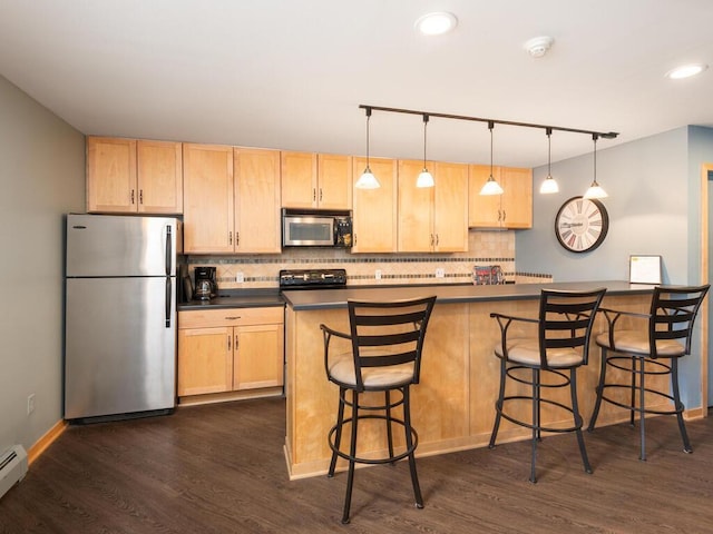 kitchen with stainless steel appliances, dark countertops, and light brown cabinetry