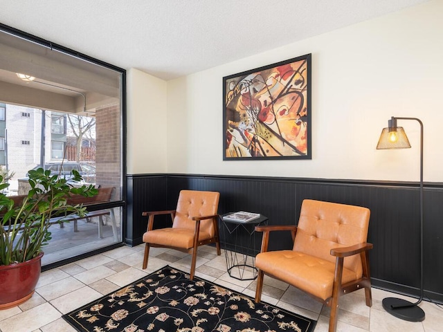 sitting room featuring wainscoting and tile patterned floors