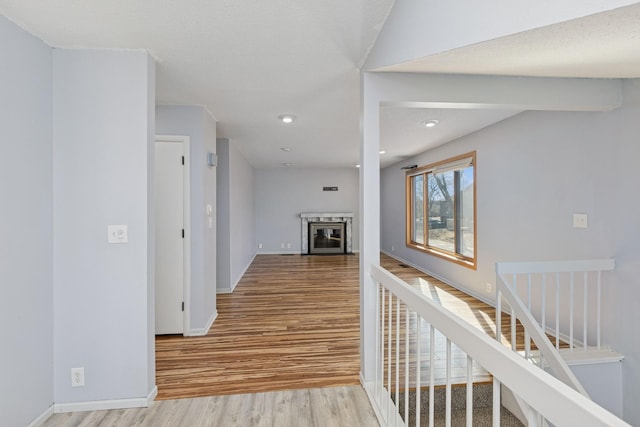 hallway featuring recessed lighting, stairway, baseboards, and wood finished floors