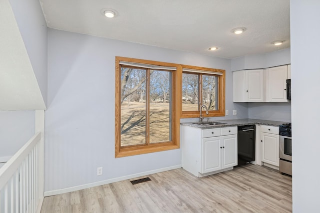 kitchen featuring stainless steel range with gas cooktop, black dishwasher, visible vents, white cabinets, and a sink