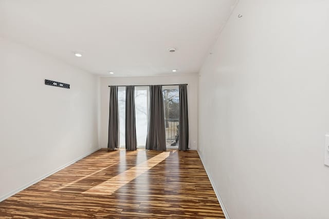 empty room featuring baseboards and wood finished floors