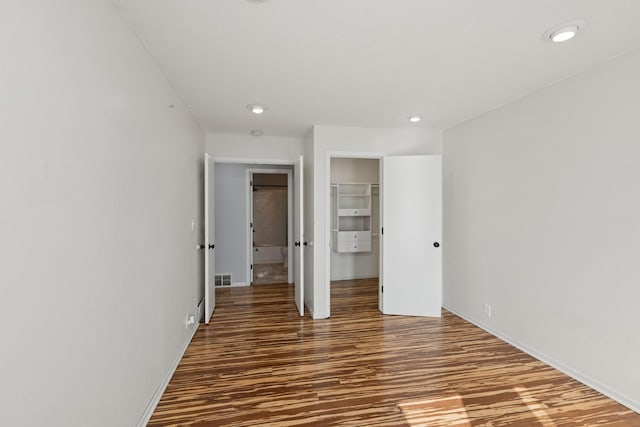 unfurnished bedroom featuring baseboards, visible vents, wood finished floors, a closet, and recessed lighting