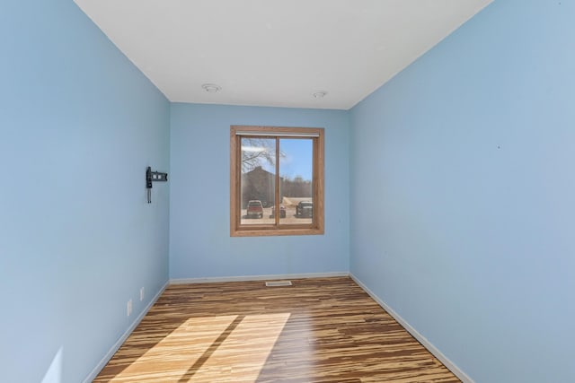 spare room with wood finished floors and baseboards