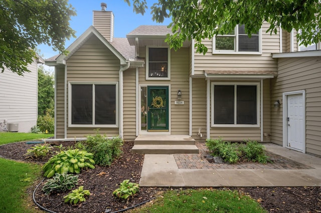 view of front of home featuring a shingled roof, a chimney, and central air condition unit