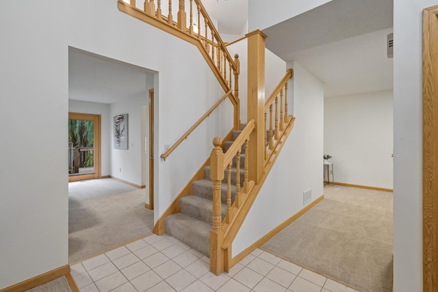 staircase featuring carpet, visible vents, and baseboards