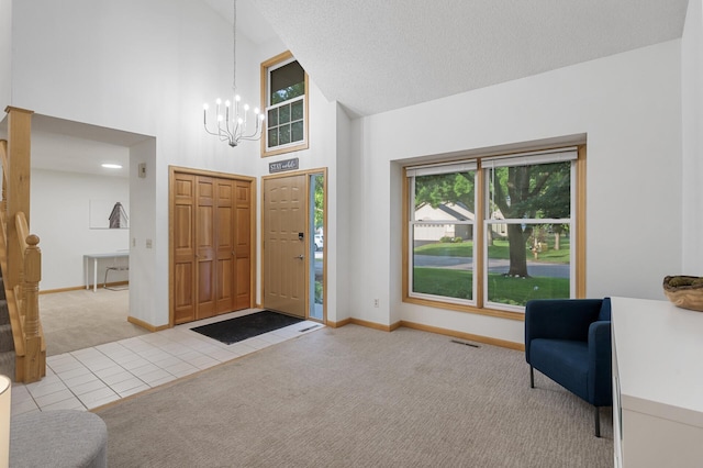 carpeted foyer entrance featuring a chandelier, high vaulted ceiling, baseboards, and tile patterned floors