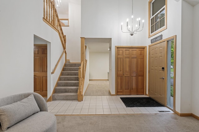 tiled entrance foyer with stairs, carpet, baseboards, and a notable chandelier