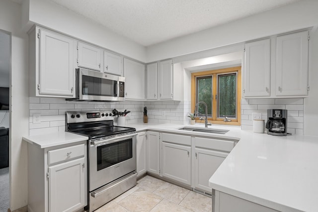 kitchen with stainless steel appliances, a sink, light countertops, and decorative backsplash