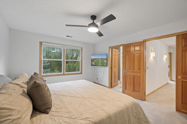 bedroom with light colored carpet, visible vents, a ceiling fan, a textured ceiling, and baseboards