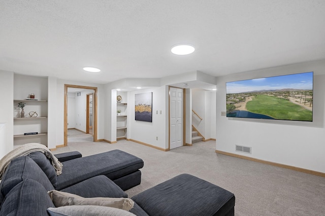 living area featuring built in shelves, visible vents, and baseboards