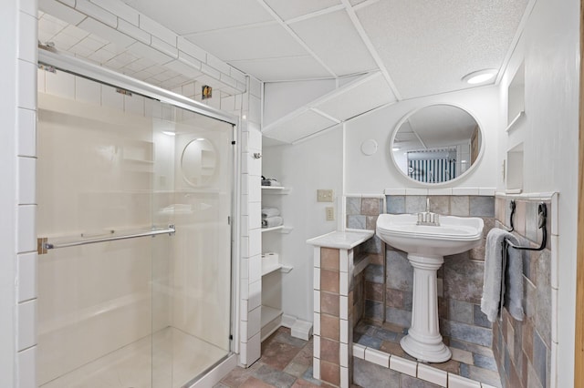 bathroom with a shower stall and stone finish floor