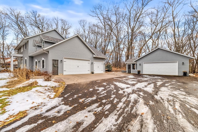 view of property exterior featuring a garage, a shingled roof, and driveway