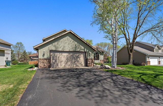 3220 Highlands Rd, Brooklyn Park, MN 55443 - view of property exterior with brick siding, asphalt driveway, a yard, and a garage
