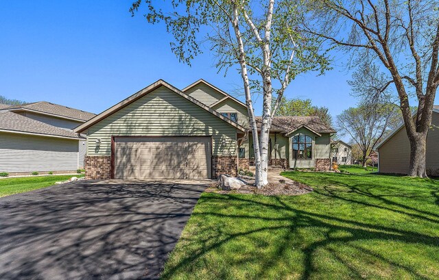 3220 Highlands Rd, Brooklyn Park, MN 55443 - view of front of house with a garage, driveway, brick siding, and a front lawn