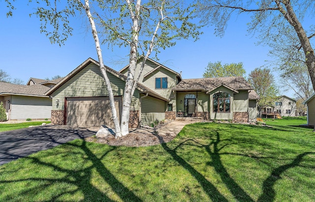 3220 Highlands Rd, Brooklyn Park, MN 55443 - split level home featuring a garage, driveway, brick siding, and a front yard