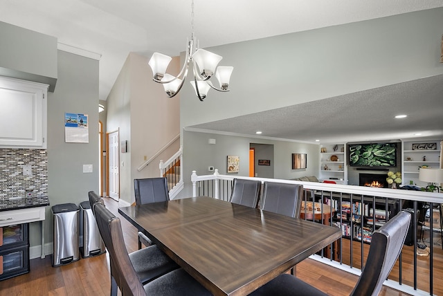 3220 Highlands Rd, Brooklyn Park, MN 55443 - dining room featuring wood finished floors, a chandelier, stairs, a lit fireplace, and recessed lighting