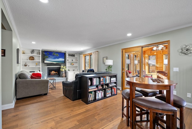 3220 Highlands Rd, Brooklyn Park, MN 55443 - living area featuring a textured ceiling, crown molding, a warm lit fireplace, and wood finished floors